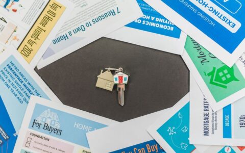 Overhead view of real estate brochures and house key, ideal for marketing.